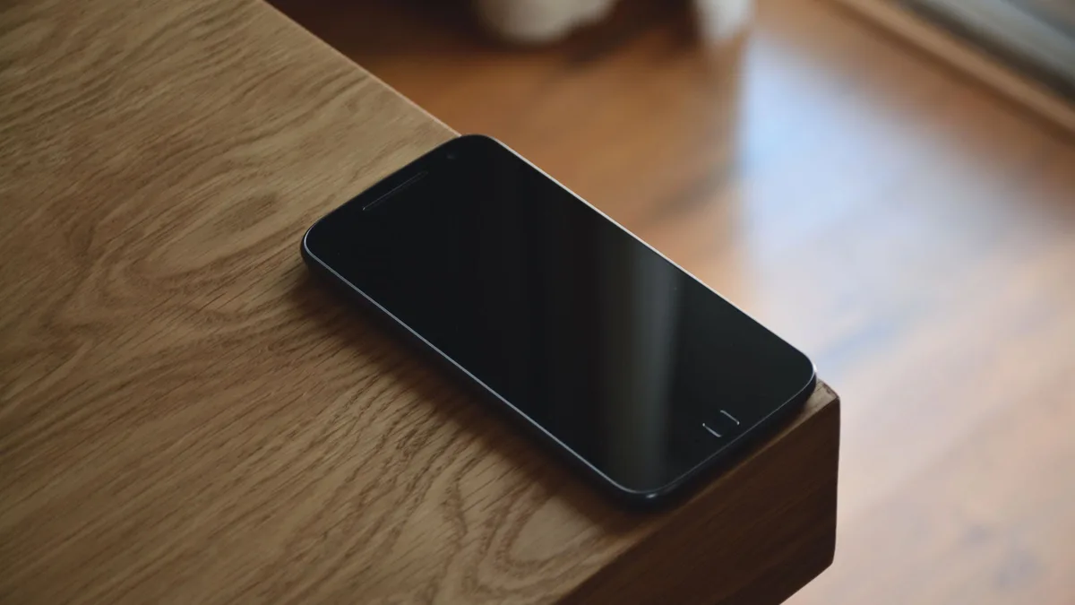 A smartphone resting on a wooden table, representing a business line during phone number porting
