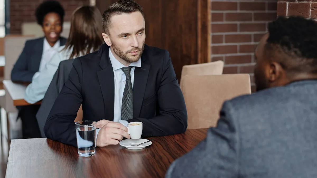 A business owner and an advisor talking across a table about phone number porting