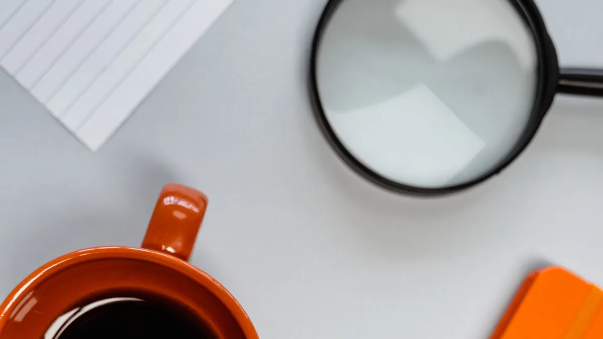 A magnifying glass and coffee mug on a desk, representing the checks after a sub-account transfer