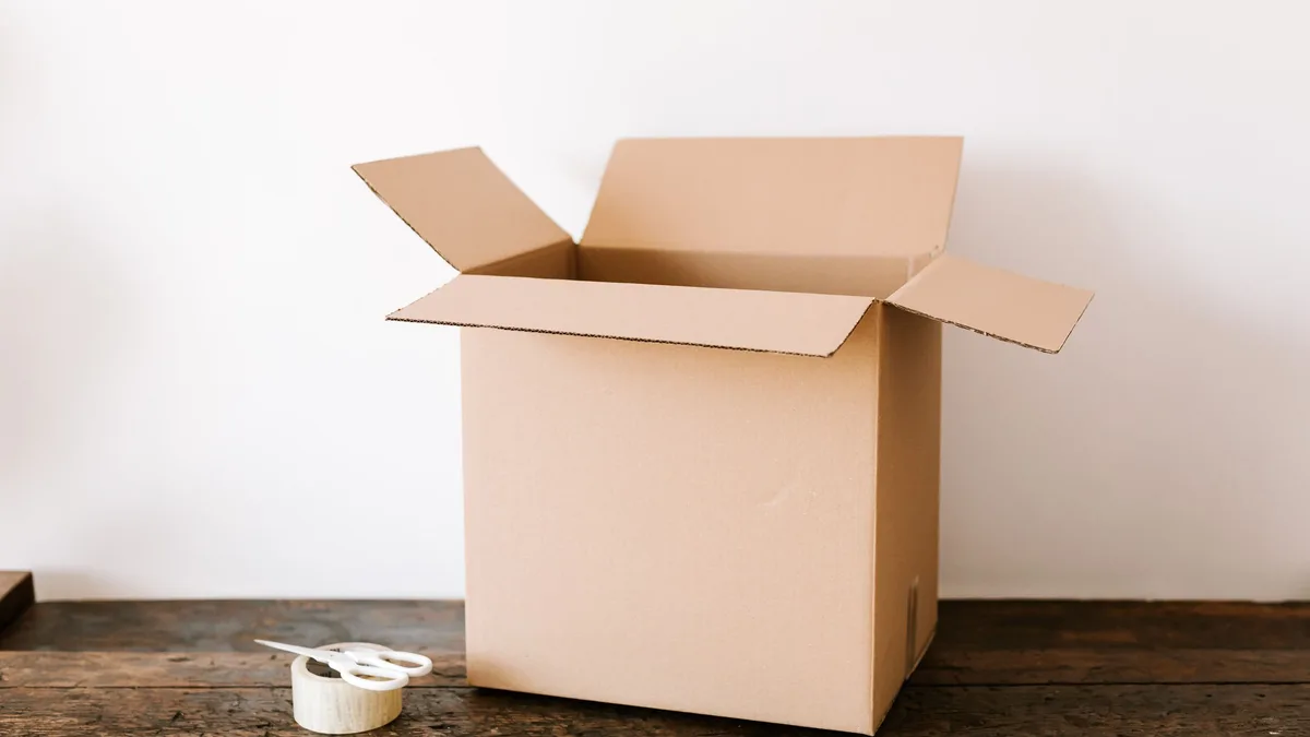 An open cardboard moving box on a wooden bench, representing what a sub-account transfer carries