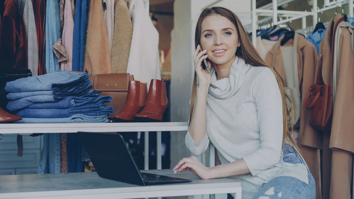 A boutique owner on a call beside her laptop, from our GHL contact first name guide
