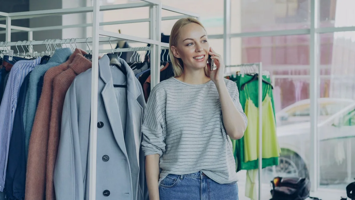 A boutique owner takes a phone call among the clothing racks, from our GHL maintenance retainer guide