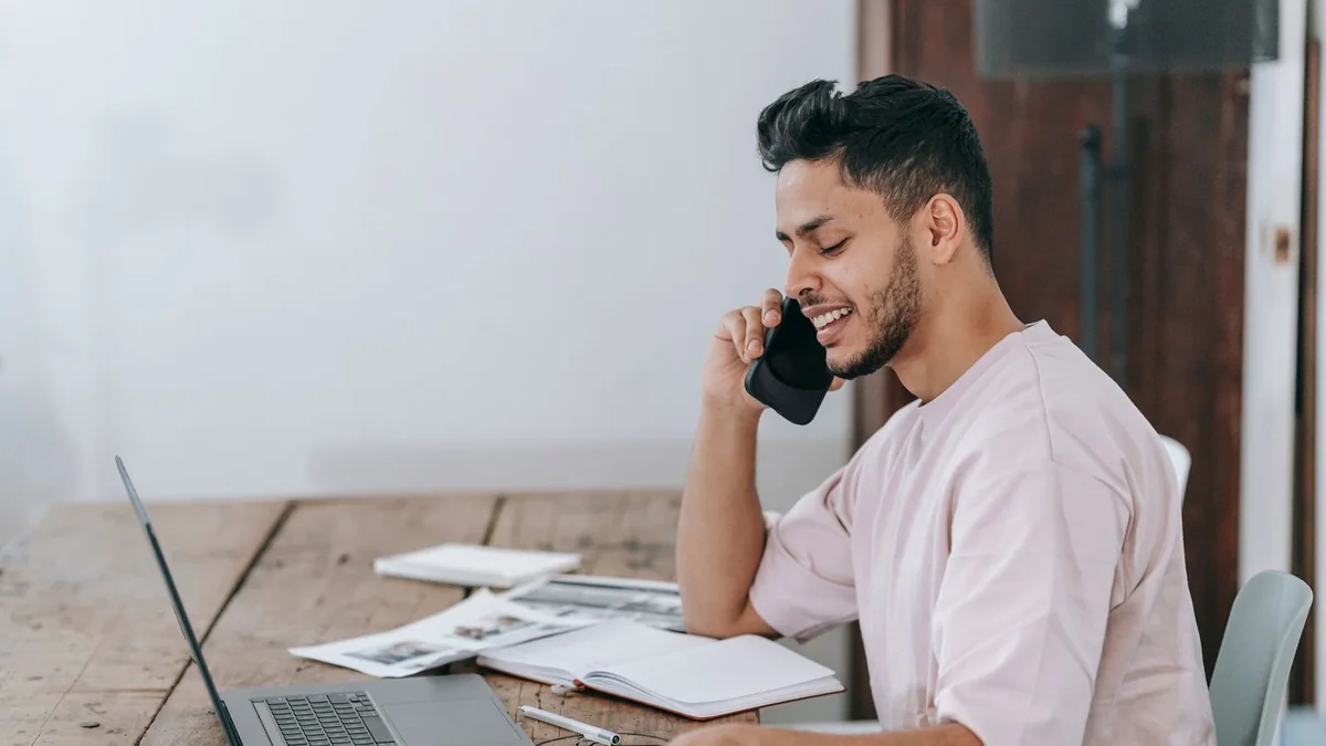 A business owner on a call while signing up at his laptop, from our GHL sign up guide