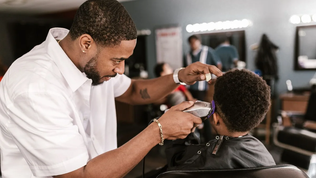 A barber cutting a client's hair in his shop, from our GHL sign up guide