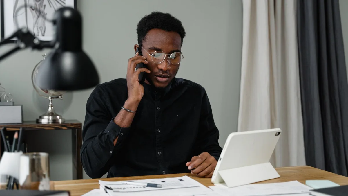 A business owner on a call at his desk, from our GHL sign up guide