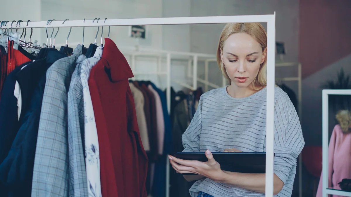 A boutique owner checks a tablet on the shop floor, from our GoHighLevel dashboard guide