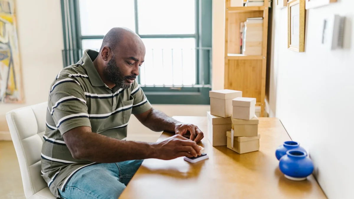 A shop owner packs orders at his worktable, from our GoHighLevel pipeline guide