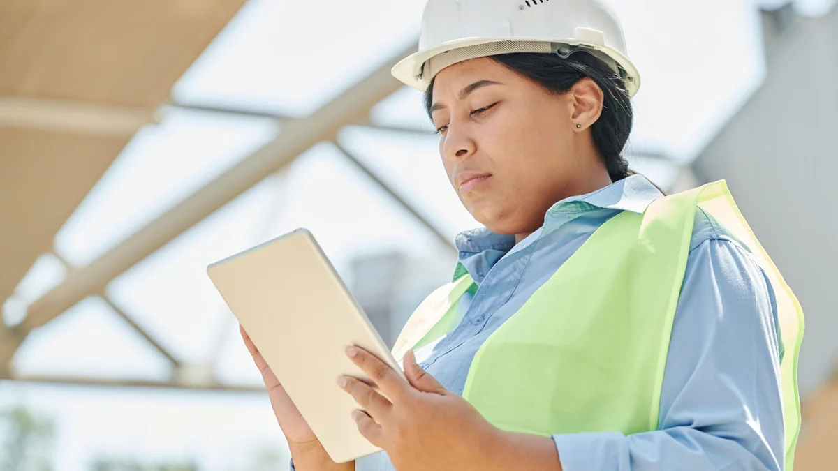 A site manager studies a tablet at a construction site, from our GoHighLevel pipeline guide