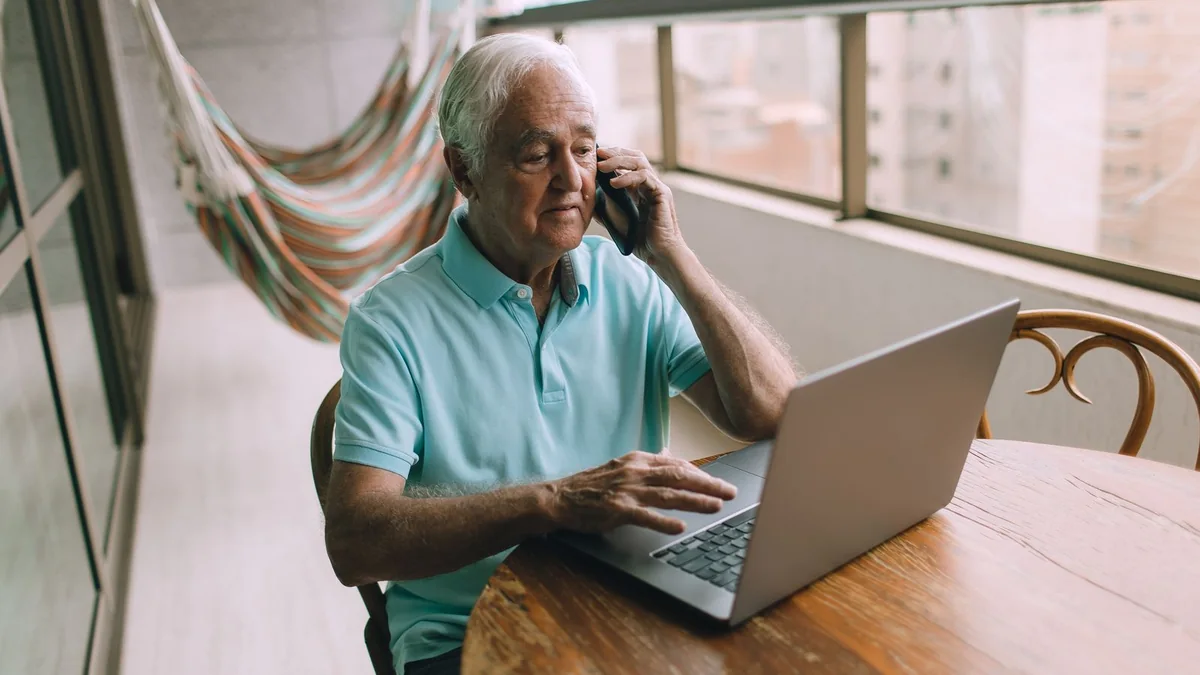 An older business owner on a call at his laptop, from our GoHighLevel reporting guide