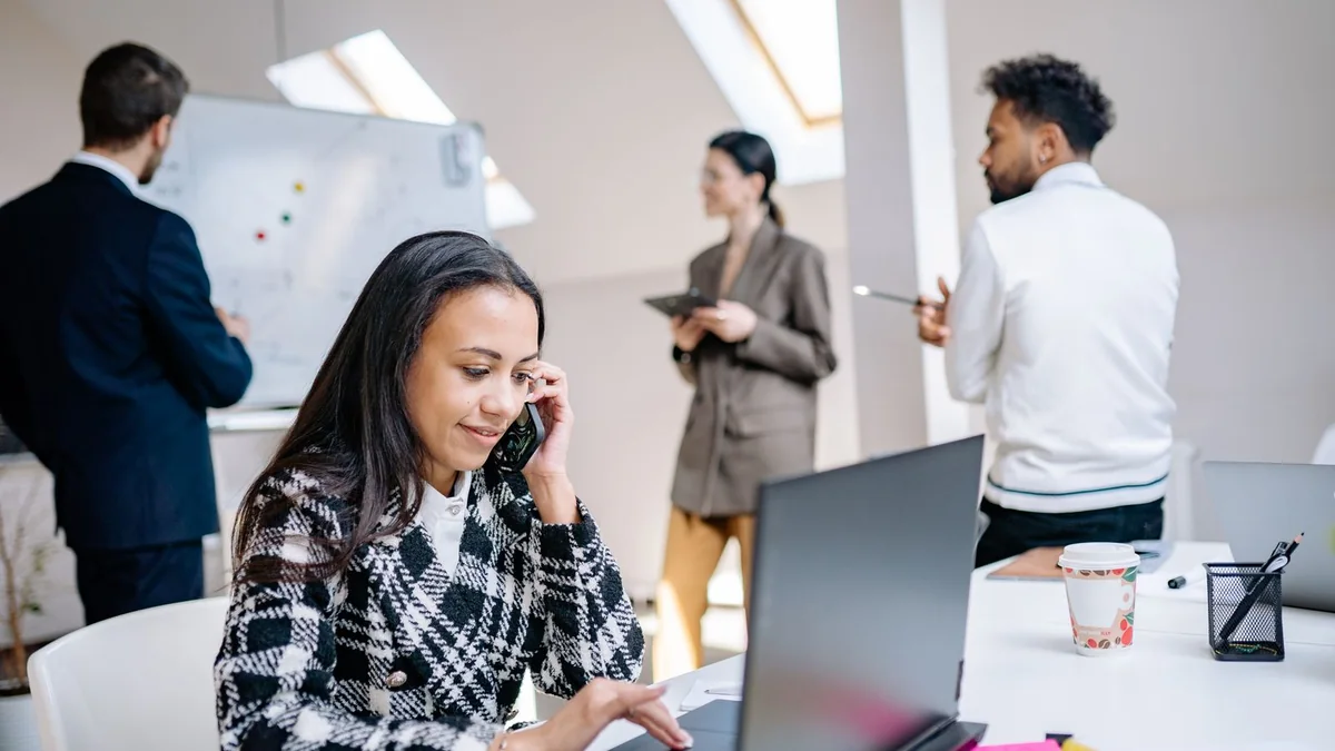 A team lead takes a call at her laptop, from our GoHighLevel reporting guide