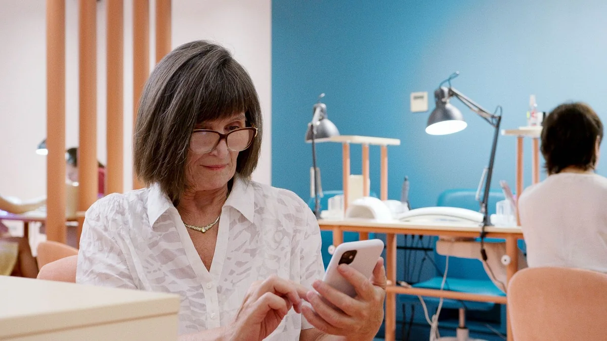 A salon owner reads her phone at her station, from our GoHighLevel support guide