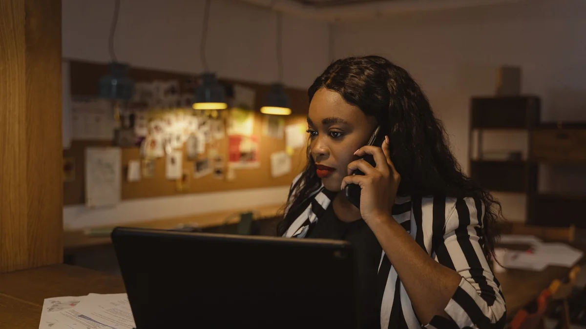A business owner answers a call at her home office desk, from our HighLevel AI pricing guide