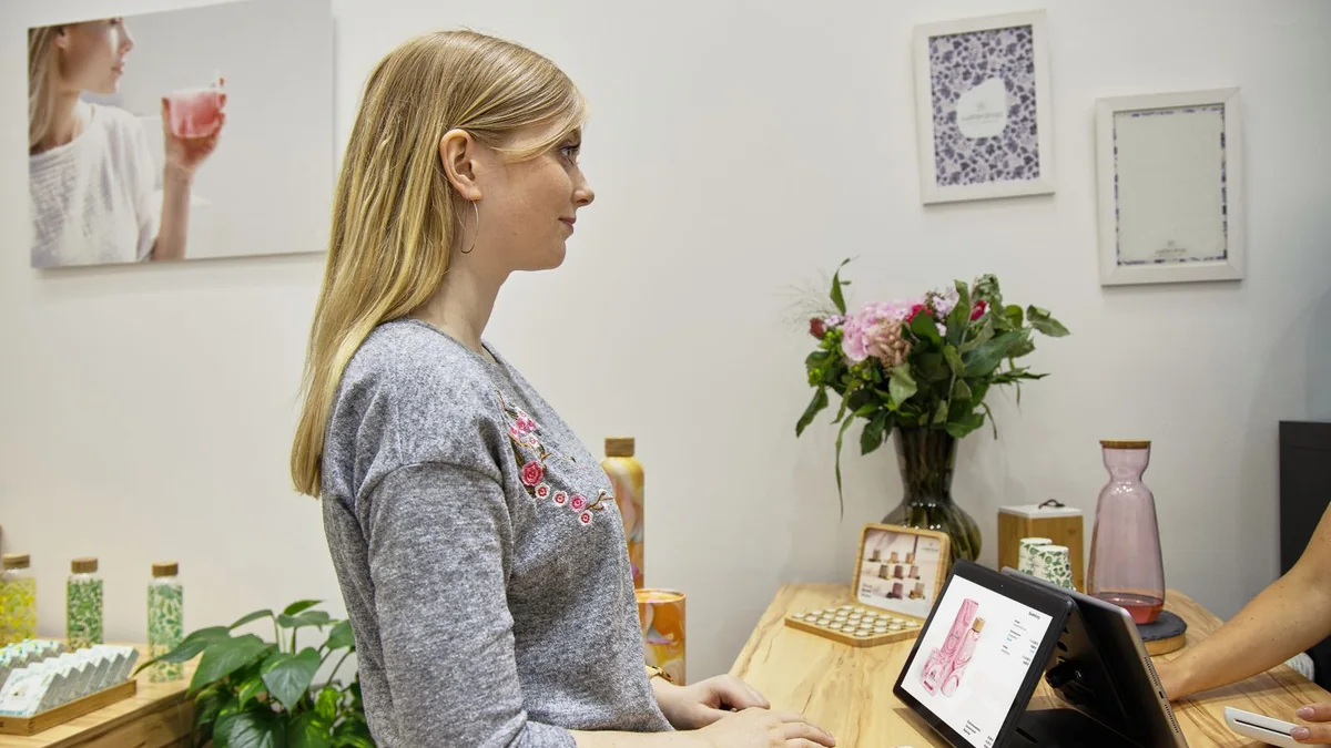 A shop owner serves a customer at the counter, from our reputation management guide
