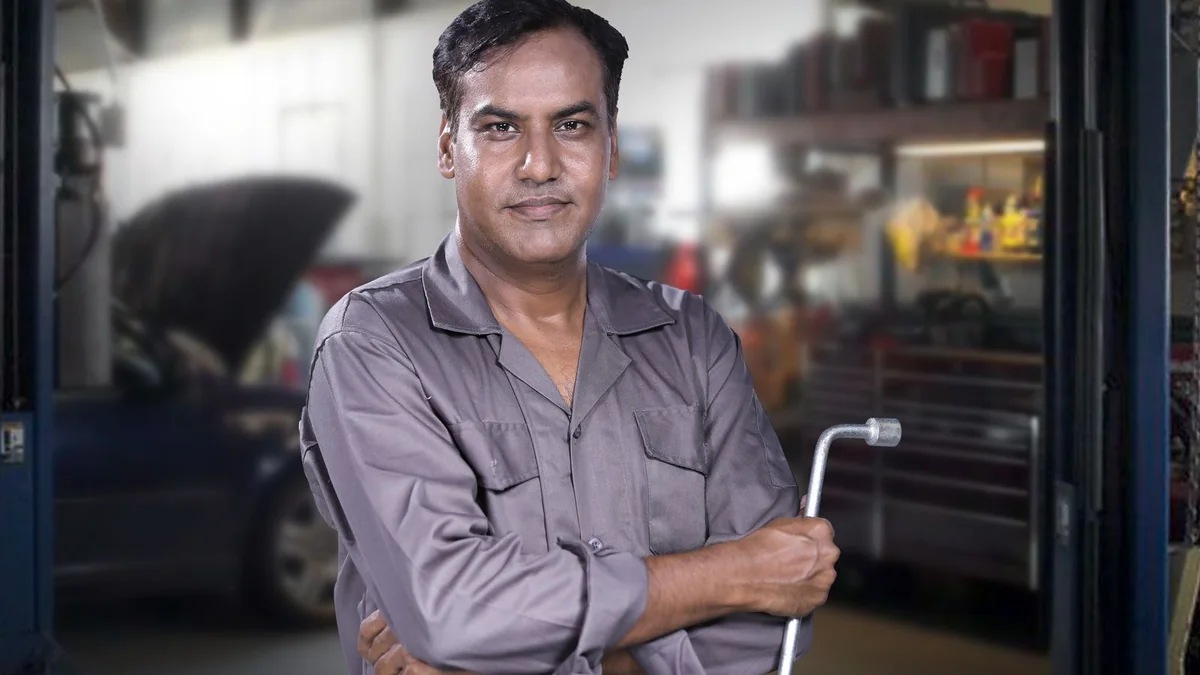 A mechanic stands in his garage with a wrench, from our reputation management guide